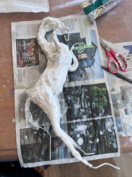 Work in progress on The Queen of Sheba, showing the white-covered horse form with exposed wire legs on a studio workbench.