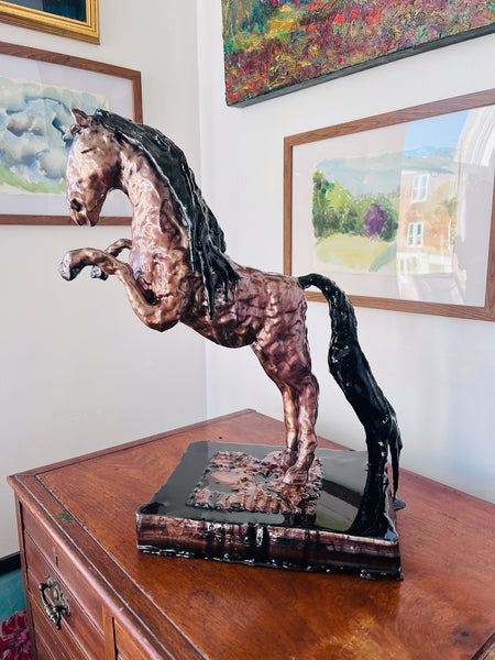 The Queen of Sheba by Stephanie Fuller, a rearing horse sculpture in resin and mica, with a copper-coloured body and black mane and tail, on a glossy black base.
